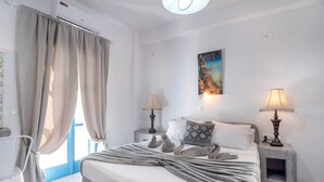 Una camera da letto con un letto, due lampade sui comodini, un quadro e una finestra con tende.