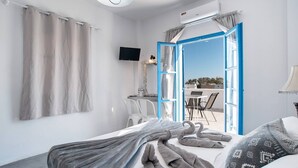 Una camera d'albergo con un letto, una TV, una scrivania e vista sull'esterno.