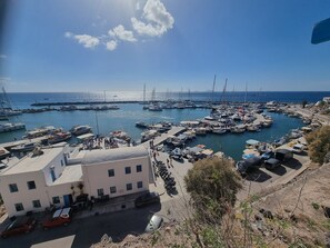 A marina with boats docked, a building with a flat roof, and a clear sky.