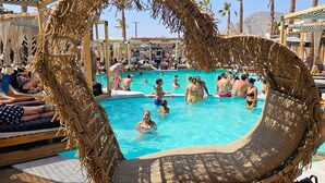 A pool area with lounge chairs and umbrellas. - Economy Quadruple Room 4 with Balcony and Air Conditioning (Perissa)