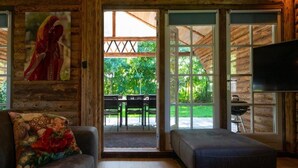A log cabin interior with a sofa, ottoman, and a television. - Spacious Wooden Chalet With Covered Terrace (Baarle-Nassau)
