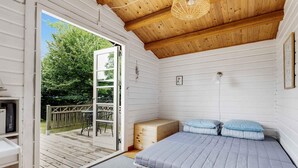 A compact bedroom with a single bed, a wooden ceiling, and a door leading to an outdoor deck. - 5 Star Holiday Home in Nykobing Sj (Sjællands Odde)