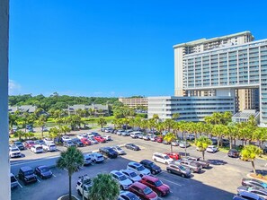 A hotel parking lot with multiple cars and palm trees. - 507 South Hampton: 2  BR, 2  BA Condominium in Myrtle Beach, Sleeps 6 (Myrtle Beach)