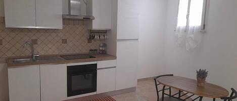 Een koelkast, een oven, een kookplaat, een koffiezetapparaat/waterkoker