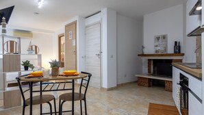 A modern kitchen with a dining area, a fireplace, and a TV. - Studio Apartment 'L'Angolo Monolocale- Porto Torres' with Shared Terrace, Wi-Fi and Air Conditioning (Porto Torres)