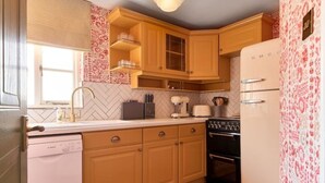 Una cocina con armarios de madera, un refrigerador blanco, una estufa y un lavavajillas.