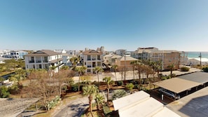 Zona residencial costeira com casas de vários andares, um estacionamento e vista para o oceano.
