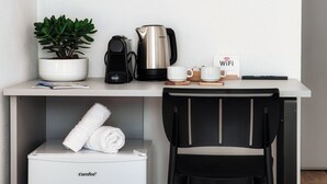 A compact workspace with a coffee maker, a potted plant, a WiFi sign, and a chair. - Batèl House 1 - By Breva Collections (Como)