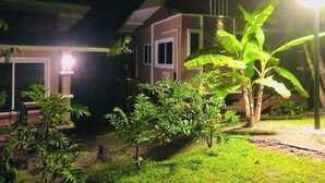 A house with a well-maintained garden at night. - Lucky Sky Homestay (Ko Pha-ngan)