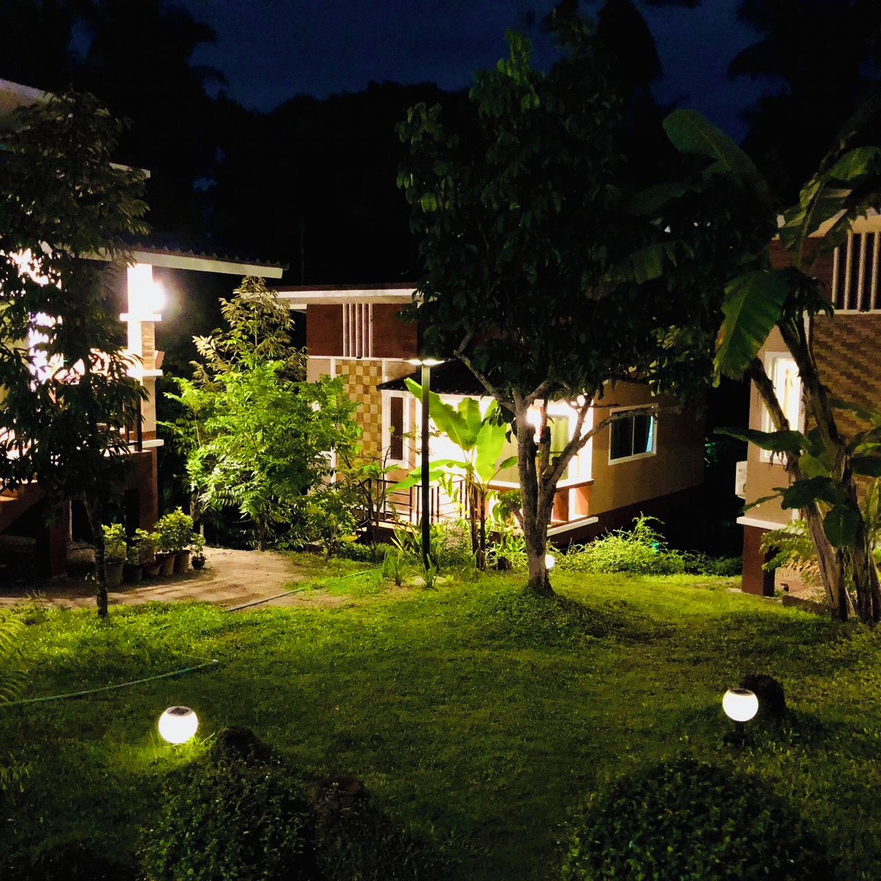 A residential area with houses, a well-maintained lawn, and a few trees.