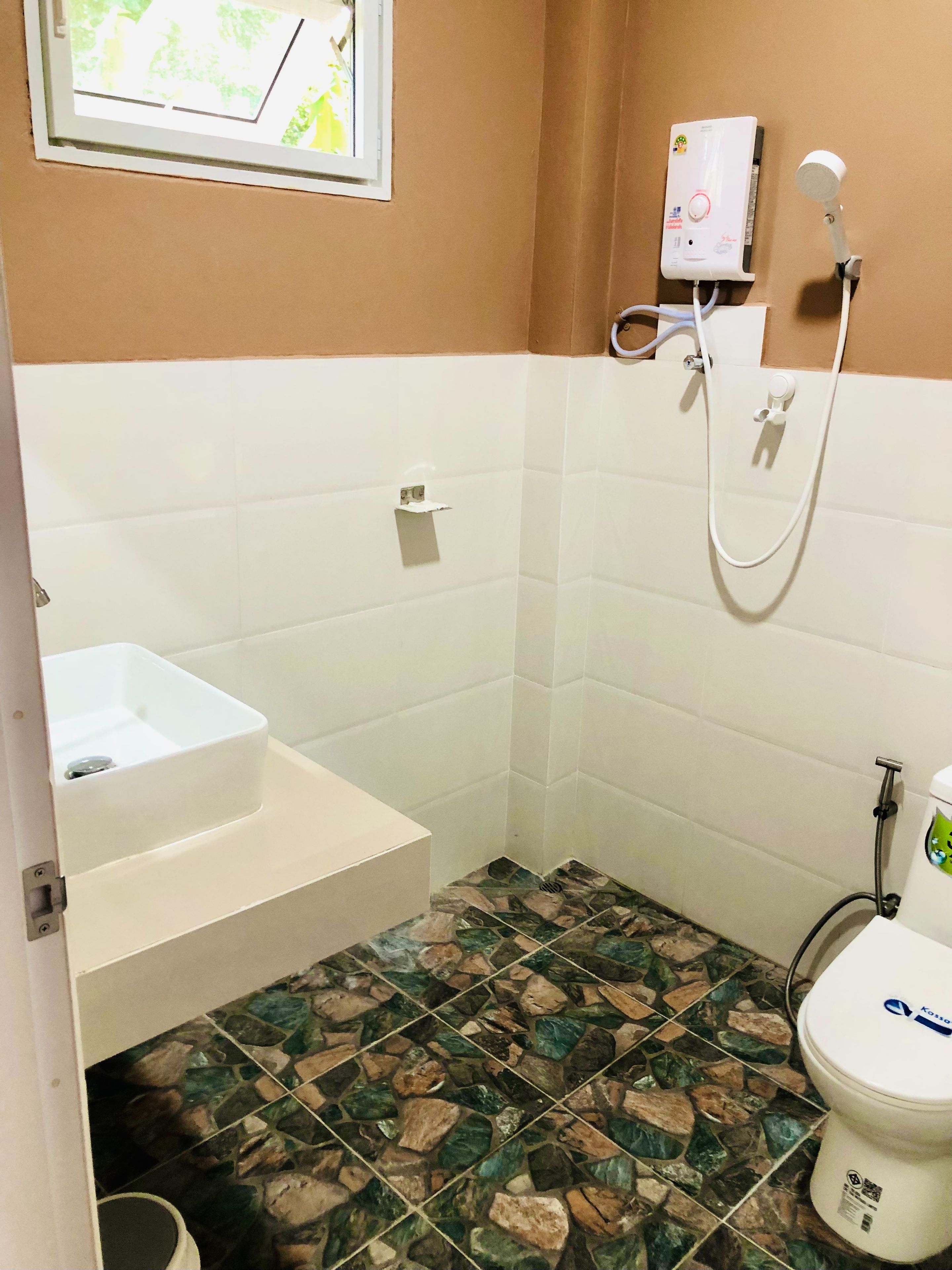 A bathroom with a white sink, a shower, and a toilet.