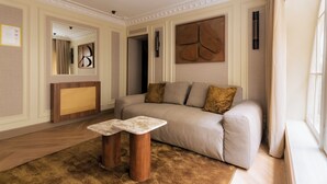 Ein modernes Wohnzimmer mit einer Couch, zwei Holznachttischen, einem großen abstrakten Wandbild und einem Spiegel.