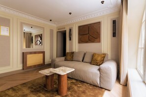 Ein modernes Wohnzimmer mit einer Couch, zwei Holznachttischen, einem großen abstrakten Wandbild und einem Spiegel.