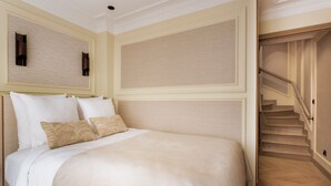 Ein Hotelzimmer mit Bett, Treppe und Wand mit strukturierter Verkleidung.