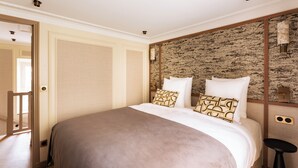 Ein Schlafzimmer mit einem großen Bett, einer Holztür und einer strukturierten Wand.