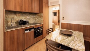 Eine moderne Küche mit Holzausstattung, einer Marmorarbeitsplatte und einem Essbereich mit einem Marmortisch.