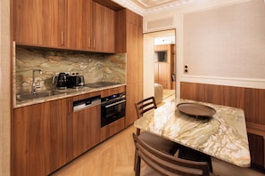 Eine moderne Küche mit Holzausstattung, einer Marmorarbeitsplatte und einem Essbereich mit einem Marmortisch.