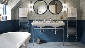 A bathroom with a white sink, two round mirrors, and a towel rack. - Townhouse by The Old Bell Hotel -68 Abbey Row (Malmesbury)