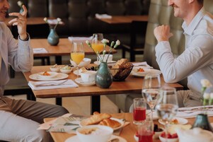 Una mesa de comedor con alimentos para el desayuno, como cruasanes, café y jugo.