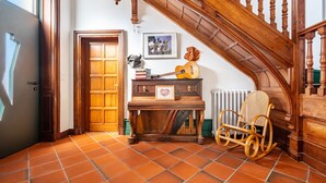 A wooden staircase with a wooden chair and a guitar on a table. - Dentelles Guest Room (Neuvic)