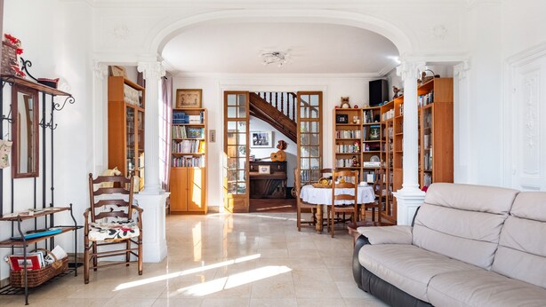 A spacious living room with a sofa, chairs, and a staircase leading to another level. - Dentelles Guest Room (Neuvic)