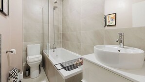 Une salle de bain moderne équipée de toilettes, d’une douche et d’un lavabo.