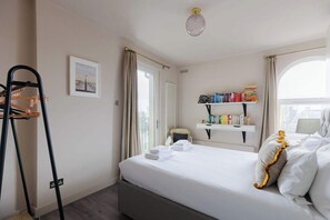 Een hotelkamer met een bed, een boekenkast, een raam en een stoel.
