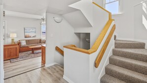 A spacious living area with a staircase leading to an upper floor.