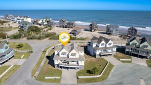 Vista aérea de una zona residencial costera con casas, una playa y el océano.