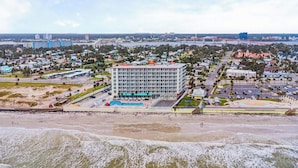 A hotel with a central courtyard, multiple floors, and a beach view.