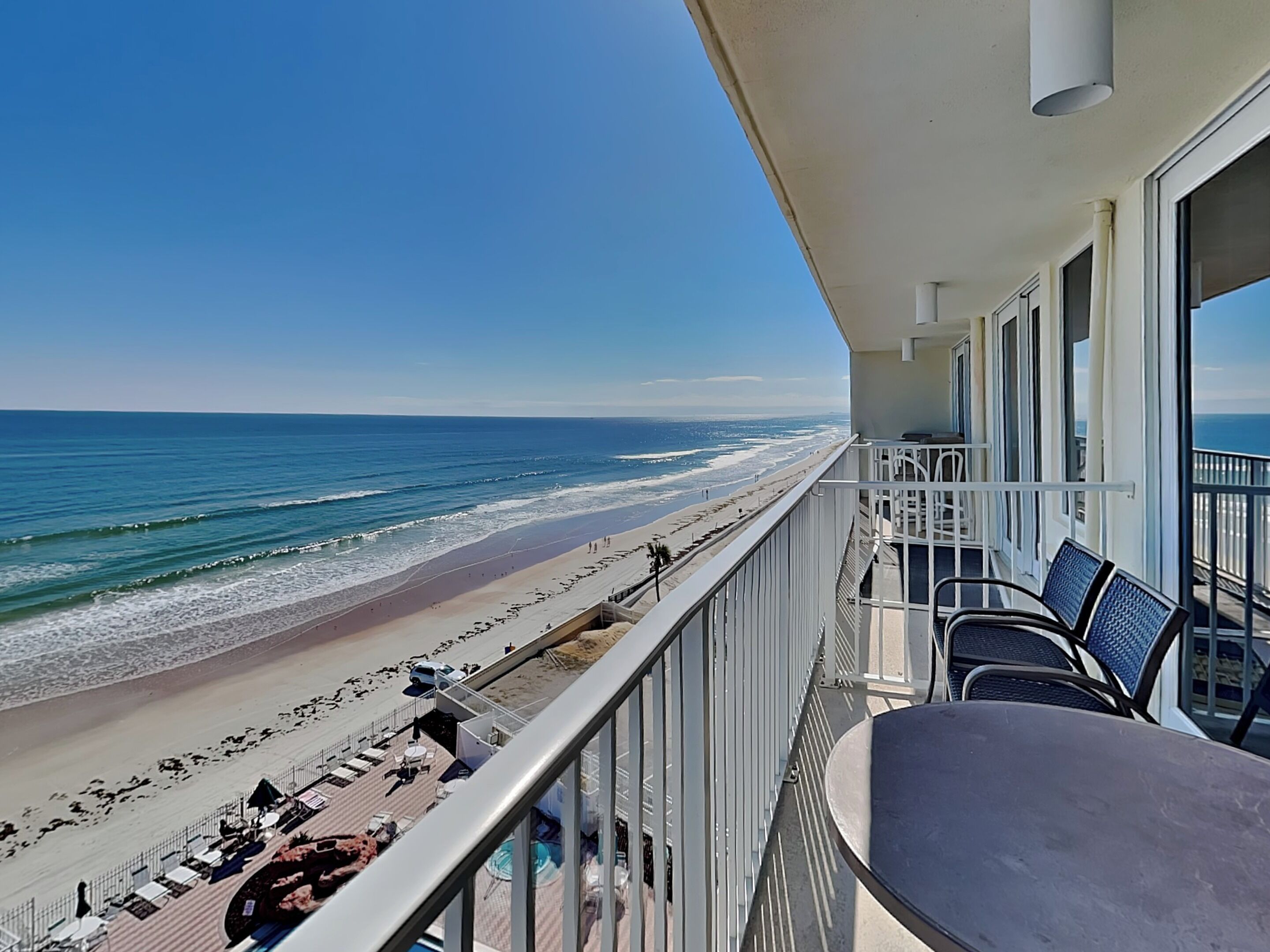 Ein Balkon mit Blick auf Strand und Meer.