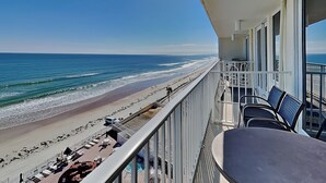 A balcony with a view of a beach and ocean.