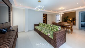Una sala de estar moderna con sofá, mesa de comedor, sillas y un espejo grande.
