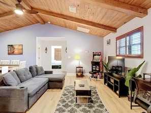 A living room with a sectional sofa, a TV, a coffee table, and a fireplace. - Canal Front, Kayak, Paddle Board, Hot Tub, Convenient Location (Tampa)