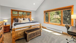 A bedroom with a wooden bed, a desk, and a large window. - Norwegian Log condo - Sleeps 8! (Steamboat Springs)