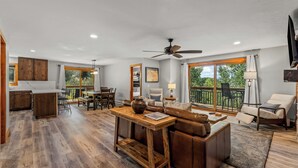 A spacious living area with a dining table, sofa, and a view of the outdoors. - Norwegian Log condo - Sleeps 8! (Steamboat Springs)