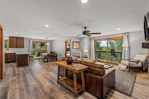 A spacious living area with a dining table, sofa, and a view of the outdoors.