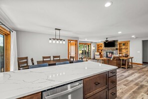 A modern kitchen with a marble countertop, wooden cabinets, and a built-in dishwasher.