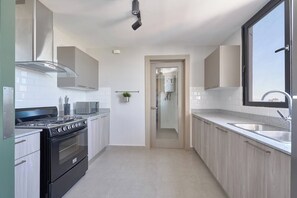 A modern kitchen with a stove, microwave, and sink.