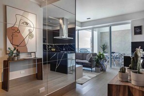 A modern living space with a kitchen, a dining area, and a balcony with a view. - ®{LUX~City~Skyline} @DowntownSD PrivéJaccuzi+Gym (Santo Domingo)