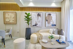 Ein modernes Wohnzimmer mit Sofa, Couchtisch und Kunstwerken an den Wänden.