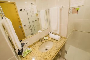 A bathroom with a sink, mirror, towel rack, and a door. - Spacious Triple Twin for Groups w/ Rooftop Gym, Sauna, Parking & Wi-Fi (Paraná)