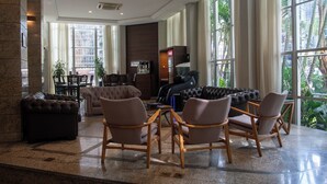 A spacious lobby with a seating area, a coffee machine, and a vending machine.