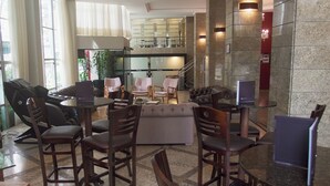 A modern lobby with a seating area, a staircase, and a view of the kitchen.