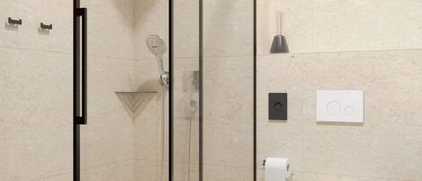 Un baño moderno con ducha de vidrio, inodoro y bidé.