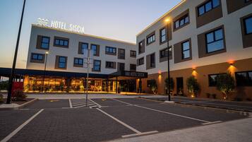 A modern hotel with a flat facade, multiple windows, and a well-lit entrance.