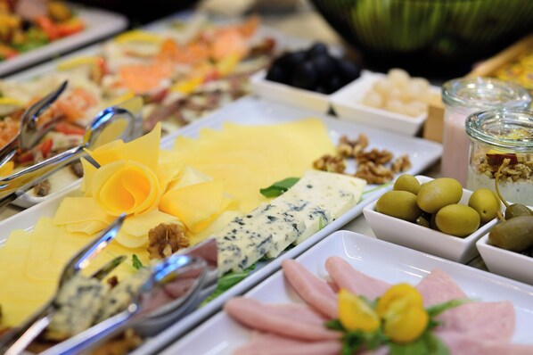 A buffet with various food items including cheese, nuts, and olives. - Hotel Siscia (Sisak)