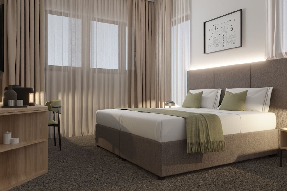 Une chambre d’hôtel moderne avec un grand lit, une table de chevet, une chaise et un bureau avec une lampe.