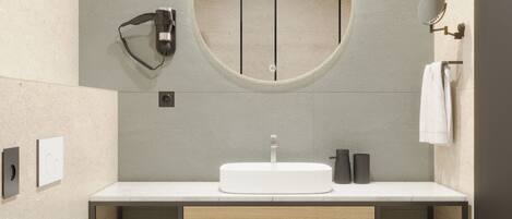 Un baño moderno con un espejo redondo, un lavabo blanco y un inodoro.