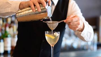 Un barman sirviendo una bebida en una copa de martini.
